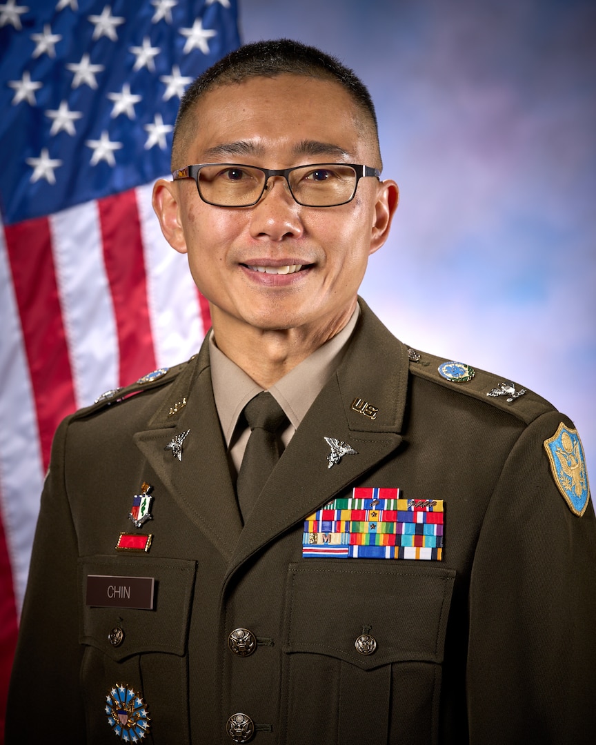 Smiling man wears glasses and an Army uniform