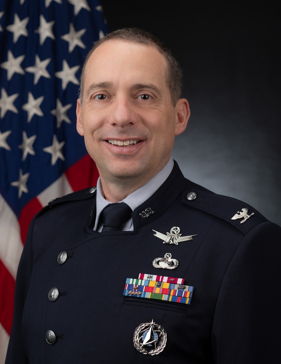 Col. Ryan C. Laughton poses smiling for a military official photo in his dress uniform.