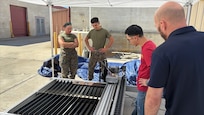 (CAMP PENDLETON, Calif.) – Marines assigned to 1st Maintenance Battalion review the results of a plasma table cutting operation with Naval Surface Warfare Center, Carderock Division engineer Brennen Cheung and Field Service Representative Justin Horn during Advanced Integrated Mobile Machine Shop (AIMMS) New Equipment Training (NET) at Camp Pendleton, California. The plasma cutting system supports expeditionary maintenance and repair operations by enabling Marines to rapidly fabricate metal components in the field.