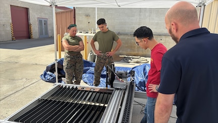 (CAMP PENDLETON, Calif.) – Marines assigned to 1st Maintenance Battalion review the results of a plasma table cutting operation with Naval Surface Warfare Center, Carderock Division engineer Brennen Cheung and Field Service Representative Justin Horn during Advanced Integrated Mobile Machine Shop (AIMMS) New Equipment Training (NET) at Camp Pendleton, California. The plasma cutting system supports expeditionary maintenance and repair operations by enabling Marines to rapidly fabricate metal components in the field.
