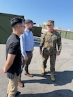 (OKINAWA, Japan) – Naval Surface Warfare Center, Carderock Division engineers Brennen Cheung and Ryan Fisher speak with Brig. Gen. Collins, commanding general of the 3rd Marine Logistics Group, about New Equipment Training (NET) supporting the recently fielded Advanced Integrated Mobile Machine Shop (AIMMS) in Okinawa, Japan. AIMMS provides Marines with a deployable manufacturing capability designed to support forward-deployed maintenance and repair operations closer to the point of need.