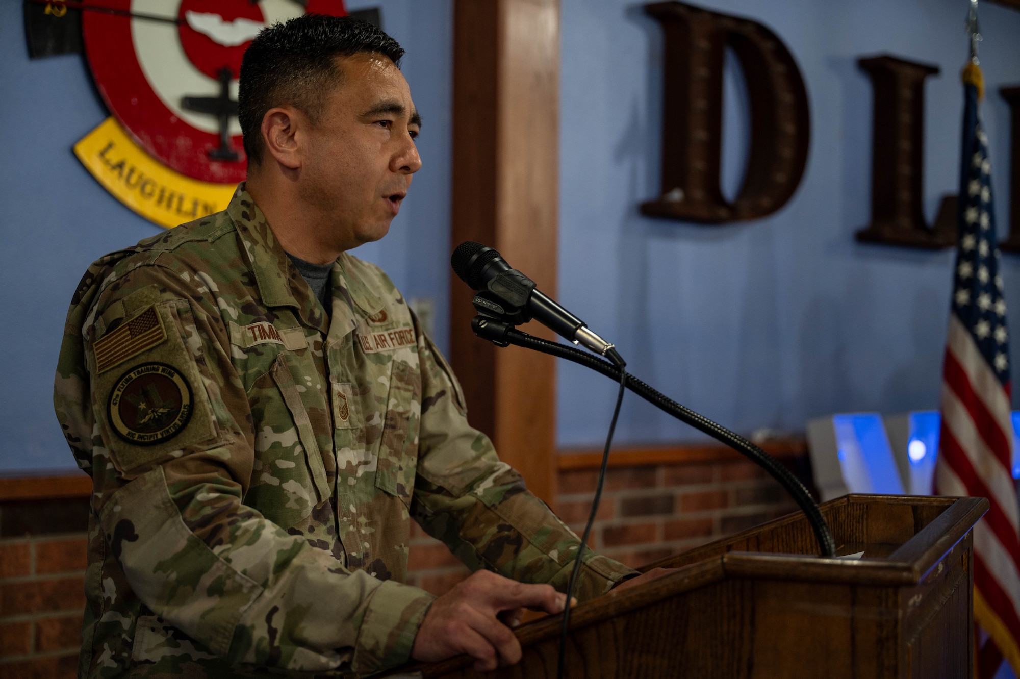 Senior Master Sgt. Andrew Timms delivers remarks at a podium.