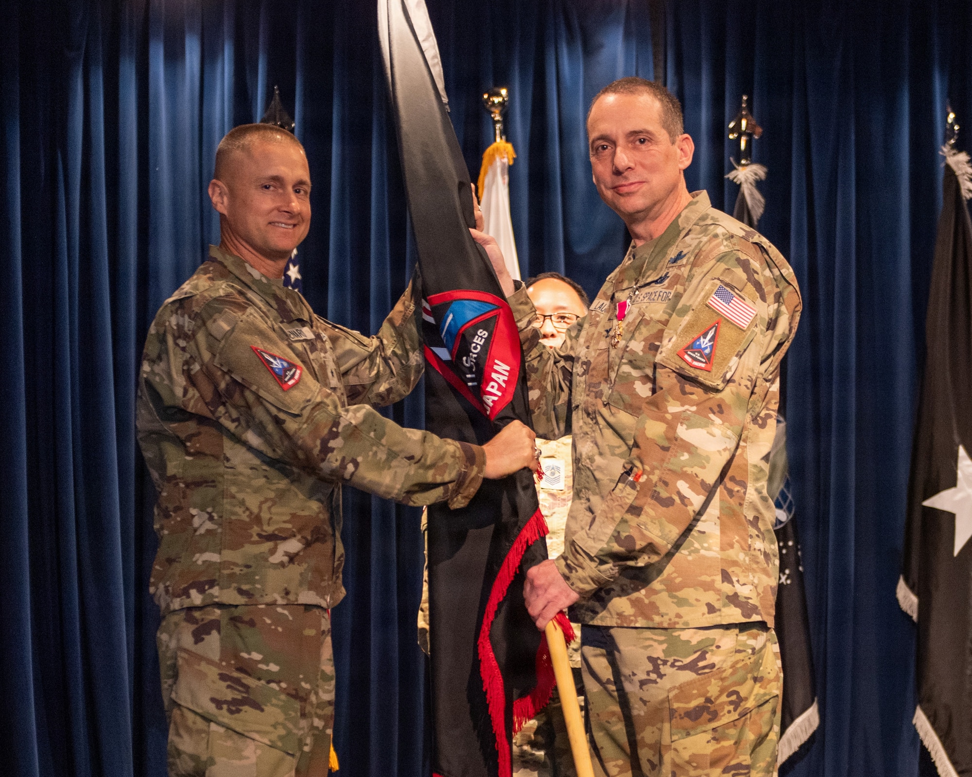 U.S. Space Force Col. Ryan Laughton, outgoing commander of U.S. Space Forces - Japan, relinquishes the guidon to U.S. Space Force Brig. Gen. Brian Denaro, U.S. Space Forces - Indo-Pacific commander, during the U.S. Space Forces - Japan change of command ceremony at Yokota Air Base, Japan, June 3, 2026.