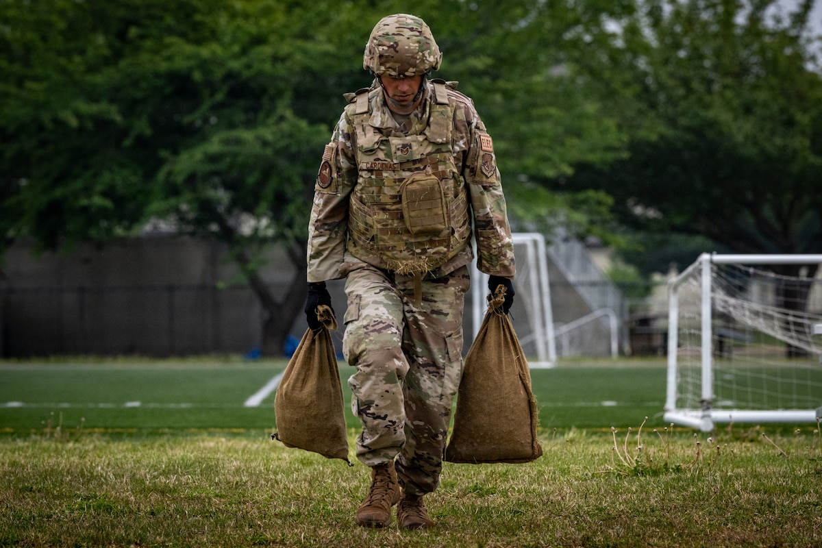 U.S. Air Force Tech. Sgt. Carlos Cardenas, 35th Civil Engineer Squadron optimizations noncommissioned officer in charge, carries sandbags during a squadron physical training session at Misawa Air Base, Japan, May 20, 2026. The session reinforced Air Force fitness standards by challenging muscular endurance, movement under load and the physical conditioning required to meet civil engineer mission demands. (U.S. Air Force photo by Senior Airman Andre Medina)