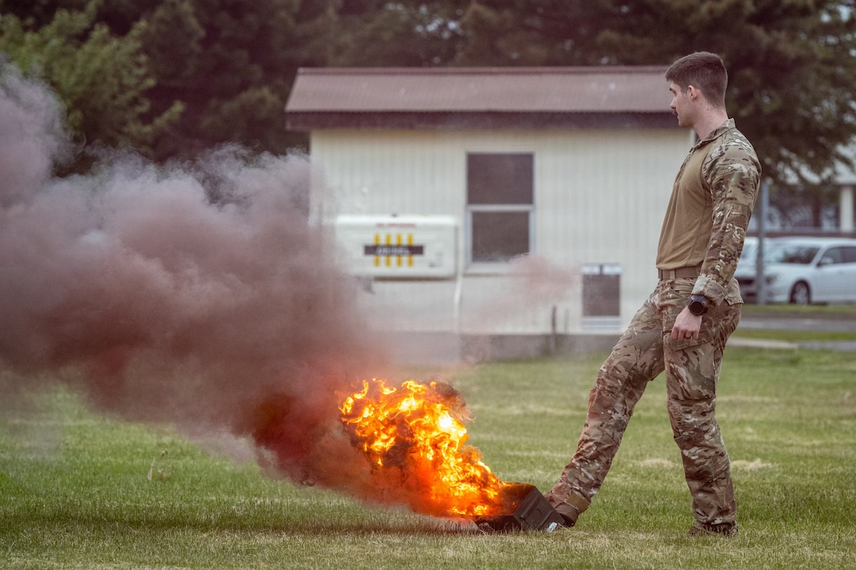 U.S. Air Force Senior Airman Justin Chamberlain, 35th Civil Engineer Squadron explosive ordnance disposal specialist, controls a field training smoke canister during a small unmanned aircraft system attack exercise at Misawa Air Base, Japan, May 20, 2026. The scenario tested Airmen’s ability to apply casualty response training and coordinate movement during a rapidly evolving threat environment. (U.S. Air Force photo by Senior Airman Andre Medina)