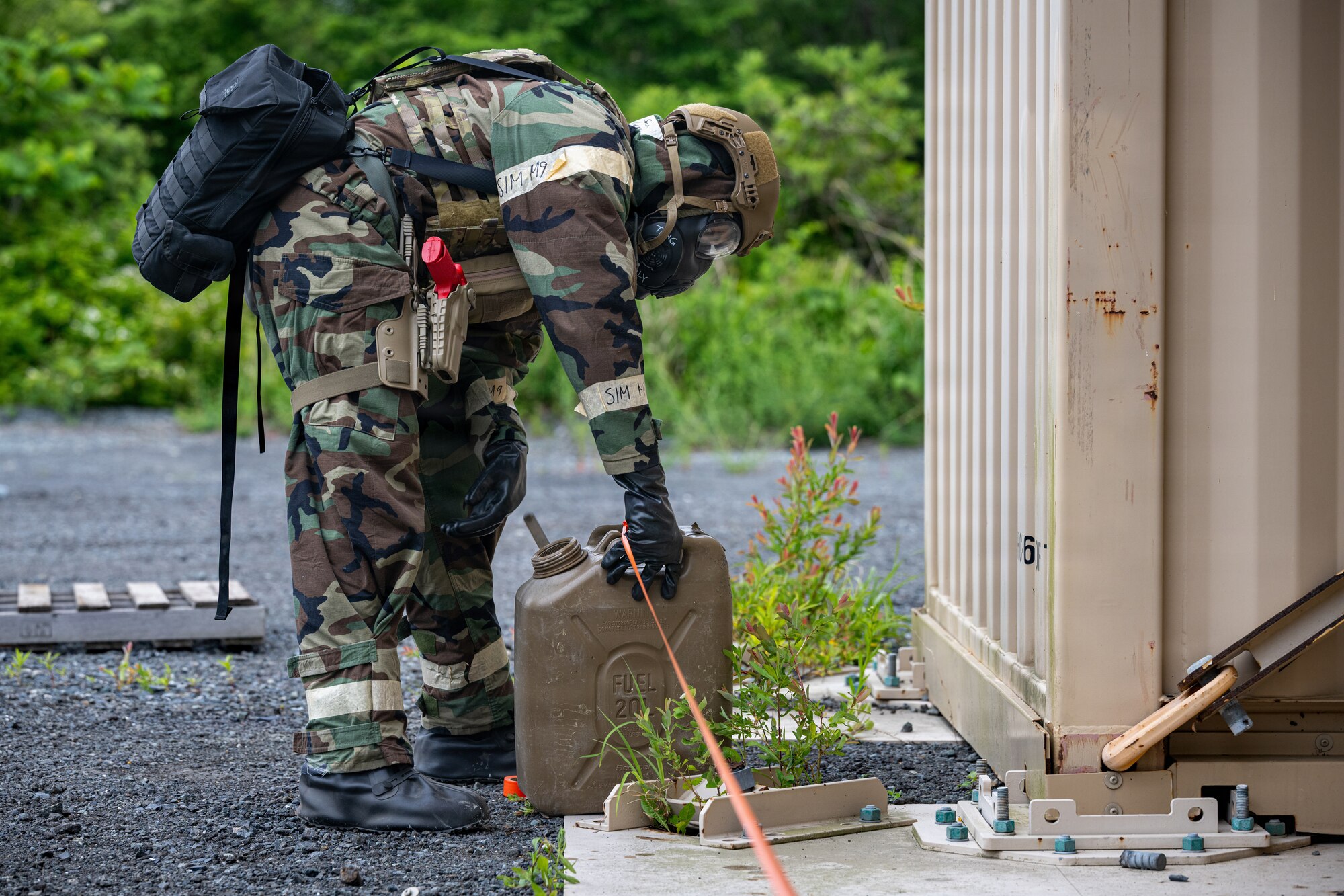 U.S. Air Force Senior Airman Nicholas Peddie, 35th Civil Engineer Squadron Emergency Management technician, simulates a hazard barricade during a chemical, biological, radiological and nuclear (CBRN) training event.