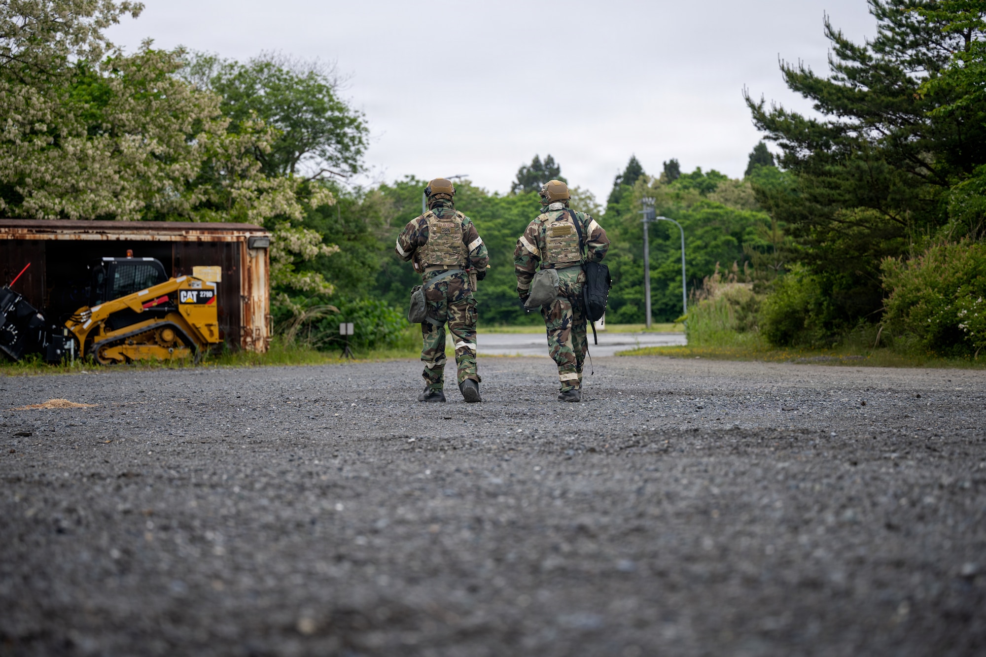 U.S. Air Force Staff Sgt. James Fink, left, 35th Civil Engineer Squadron (CES) emergency management noncommissioned officer in charge of logistics and training, and Senior Airman Nicholas Peddie, 35th CES emergency management technician, scan their surroundings for a simulated drone during a chemical, biological, radiological and nuclear training.
