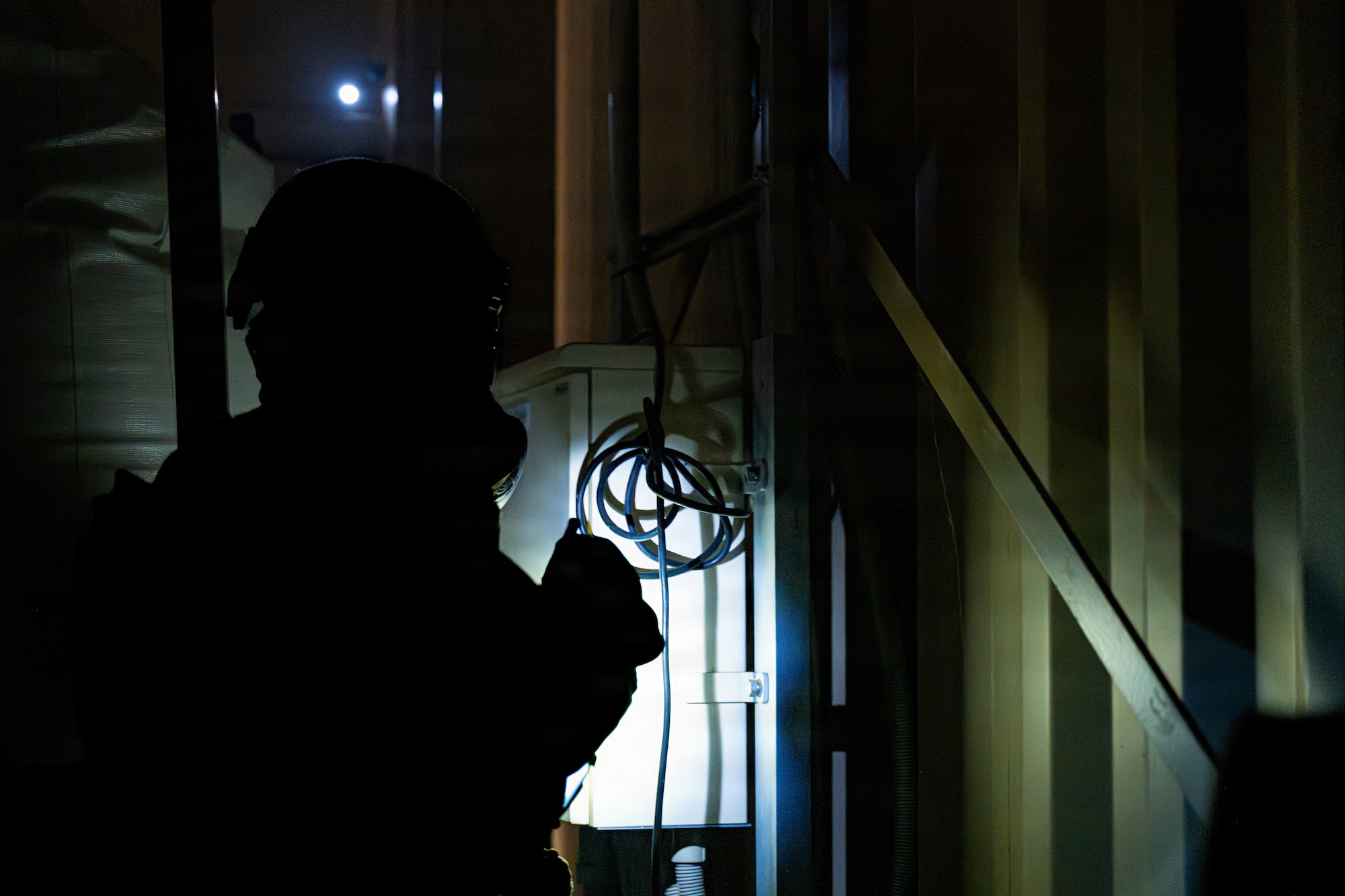 U.S. Air Force Staff Sgt. James Fink, 35th Civil Engineer Squadron Emergency Management noncommissioned officer in charge of logistics and training, scans the inside of a storage house for a simulated small unmanned aircraft system during a chemical, biological, radiological and nuclear training event.