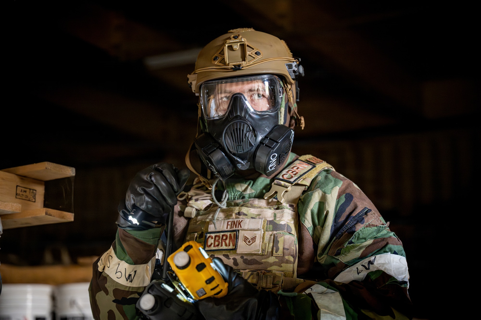 U.S. Air Force Staff Sgt. James Fink, 35th Civil Engineer Squadron Emergency Management noncommissioned officer in charge of logistics and training, scans the inside of a storage house for a simulated small unmanned aircraft system during a chemical, biological, radiological and nuclear training event.