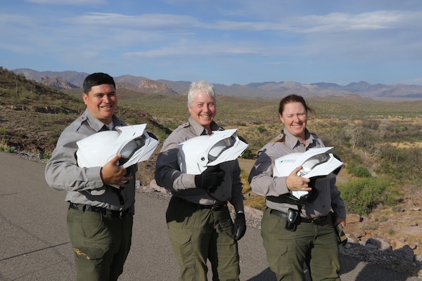 From left, Joseph Carranza Escobar, Marlene Schmitt and Emily Hibbard, park rangers with the U.S. Army Corps of Engineers, pose with their ATV helmets before preforming an environmental inspection of the Whitlow Range Dam Area May 13 near Queen Valley, Arizona.