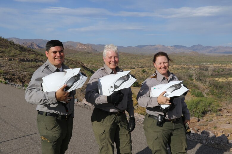 From left, Joseph Carranza Escobar, Marlene Schmitt and Emily Hibbard, park rangers with the U.S. Army Corps of Engineers, pose with their ATV helmets before preforming an environmental inspection of the Whitlow Range Dam Area May 13 near Queen Valley, Arizona.