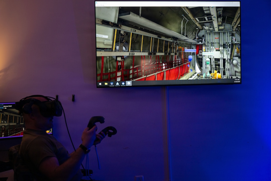 U.S. Air Force Master Sgt. Steven Sevigny uses controllers to navigate around a cargo bay in the XR Lab.