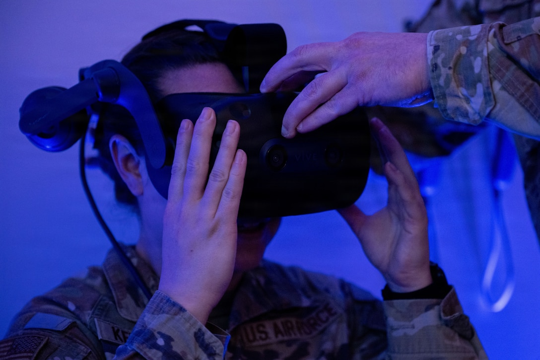 U.S. Air Force Tech. Sgt. Erin Kershner tries on a virtual reality headset in the extended reality lab.