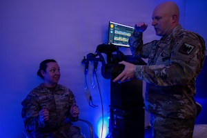 U.S. Air Force Master Sgt. Steven Sevigny, Air National Guard maintenance extended reality program manager assigned to the Air National Guard Readiness Center, explains how to put on the virtual reality headset.