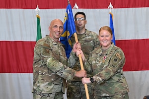 Commander Bryant and Dobbins holds the guidon flag.