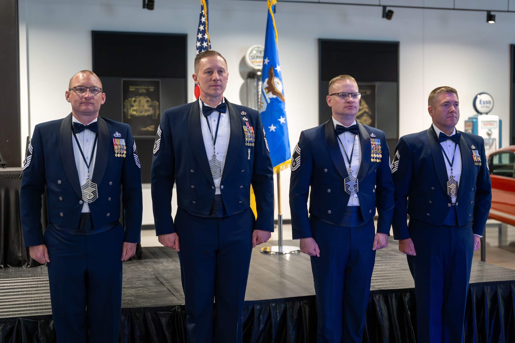 Four uniformed men standing in a row during a formal event