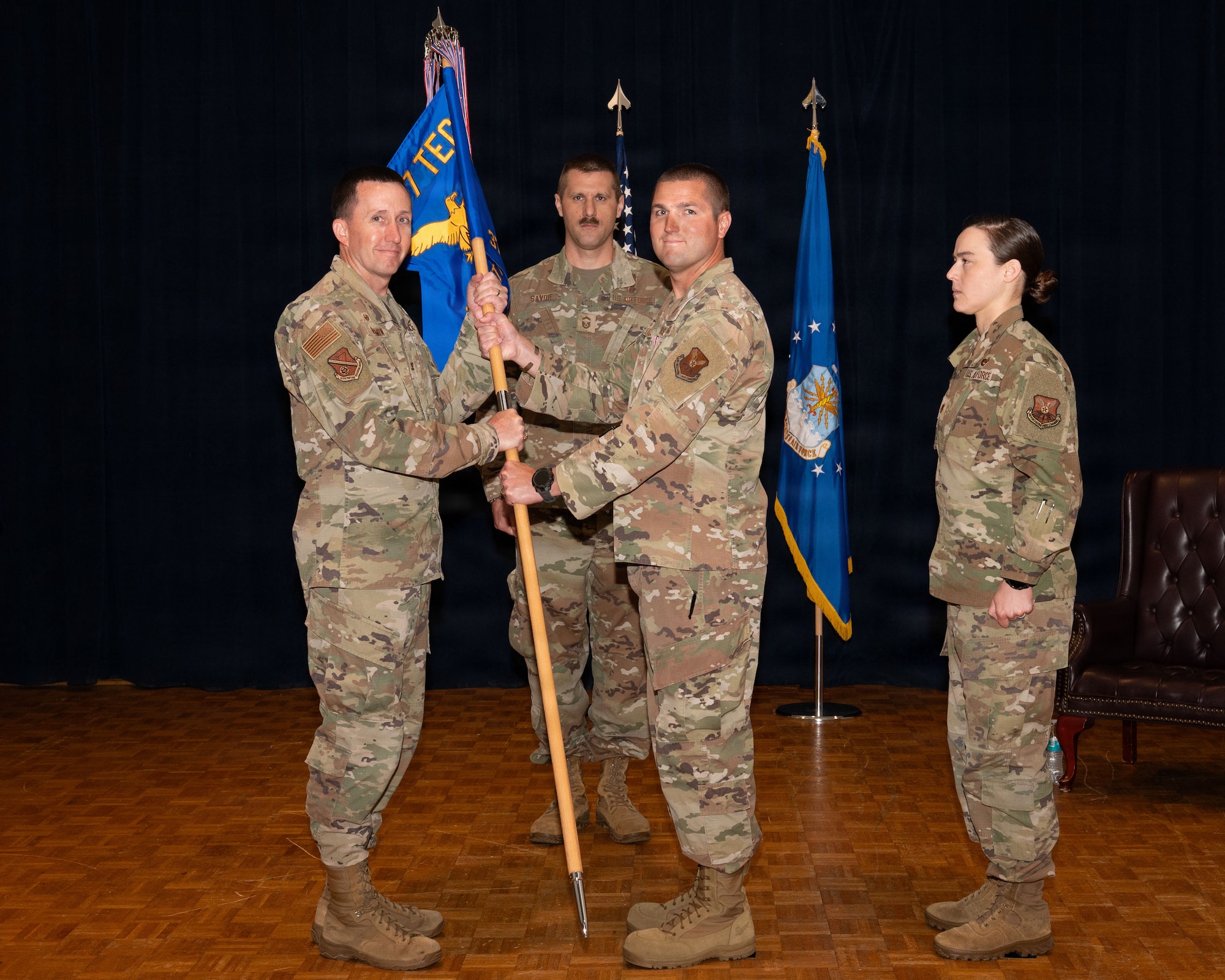 a person passes a flag to another person on a stage