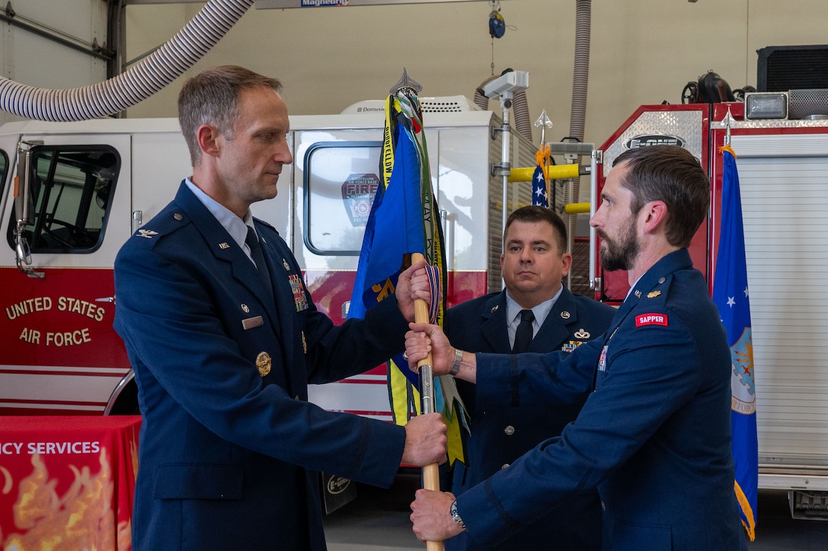 U.S. Air Force Col. Nathan Olsen, left, 17th Mission Support Group commander, passes the 17th CES guidon to Maj. Nathan Jones, right, incoming 17th Civil Engineer Squadron commander, during an assumption of command ceremony at Goodfellow Air Force Base, Texas, May 29, 2026. The passing of the guidon to Jones signifies him taking command of the 17th CES. (U.S. Air Force photo by Senior Airman James Salellas)