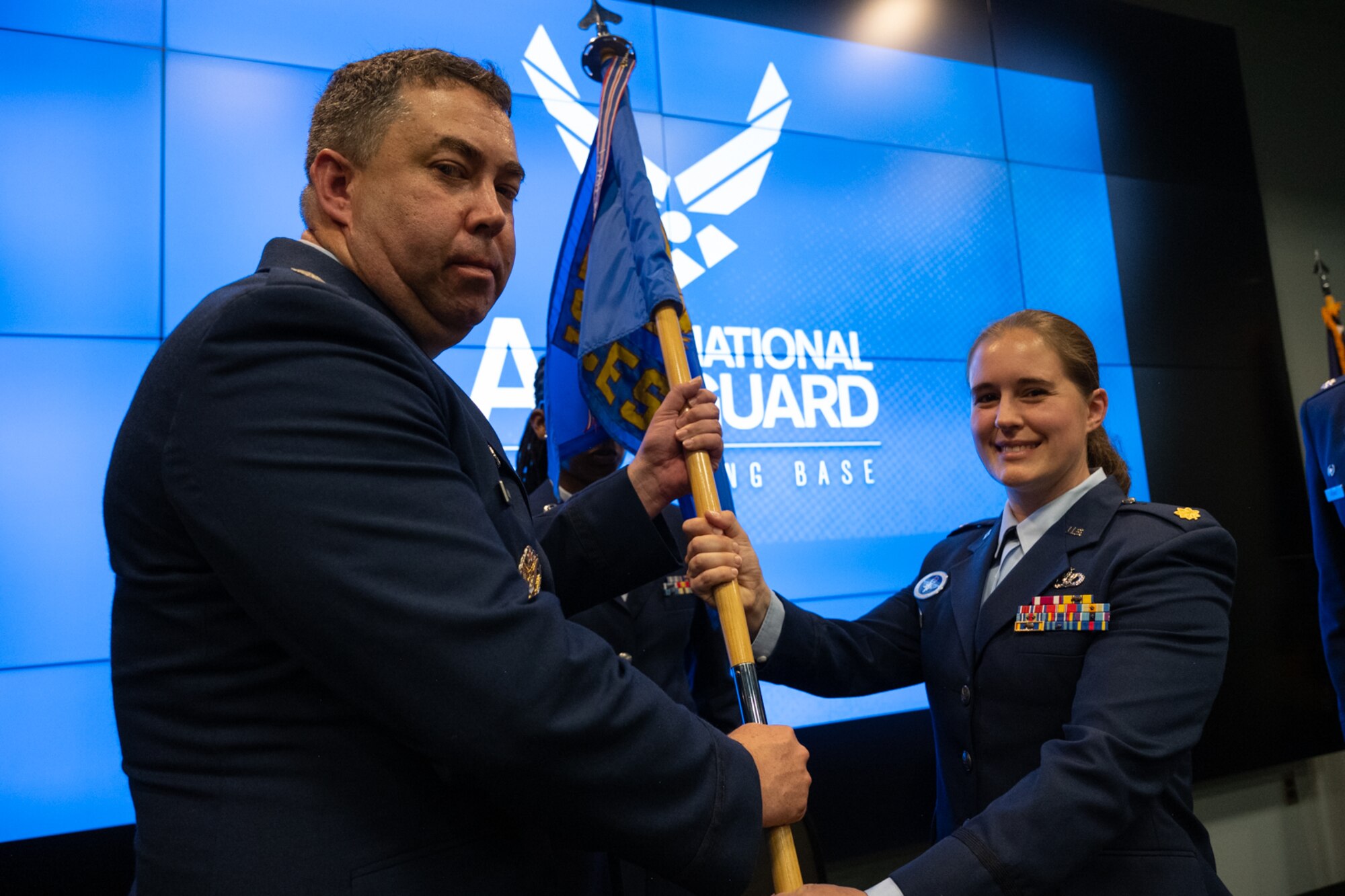 105th Mission Support Group commander passes the guidon to the incoming 105th Civil Engineer Squadron commander.
