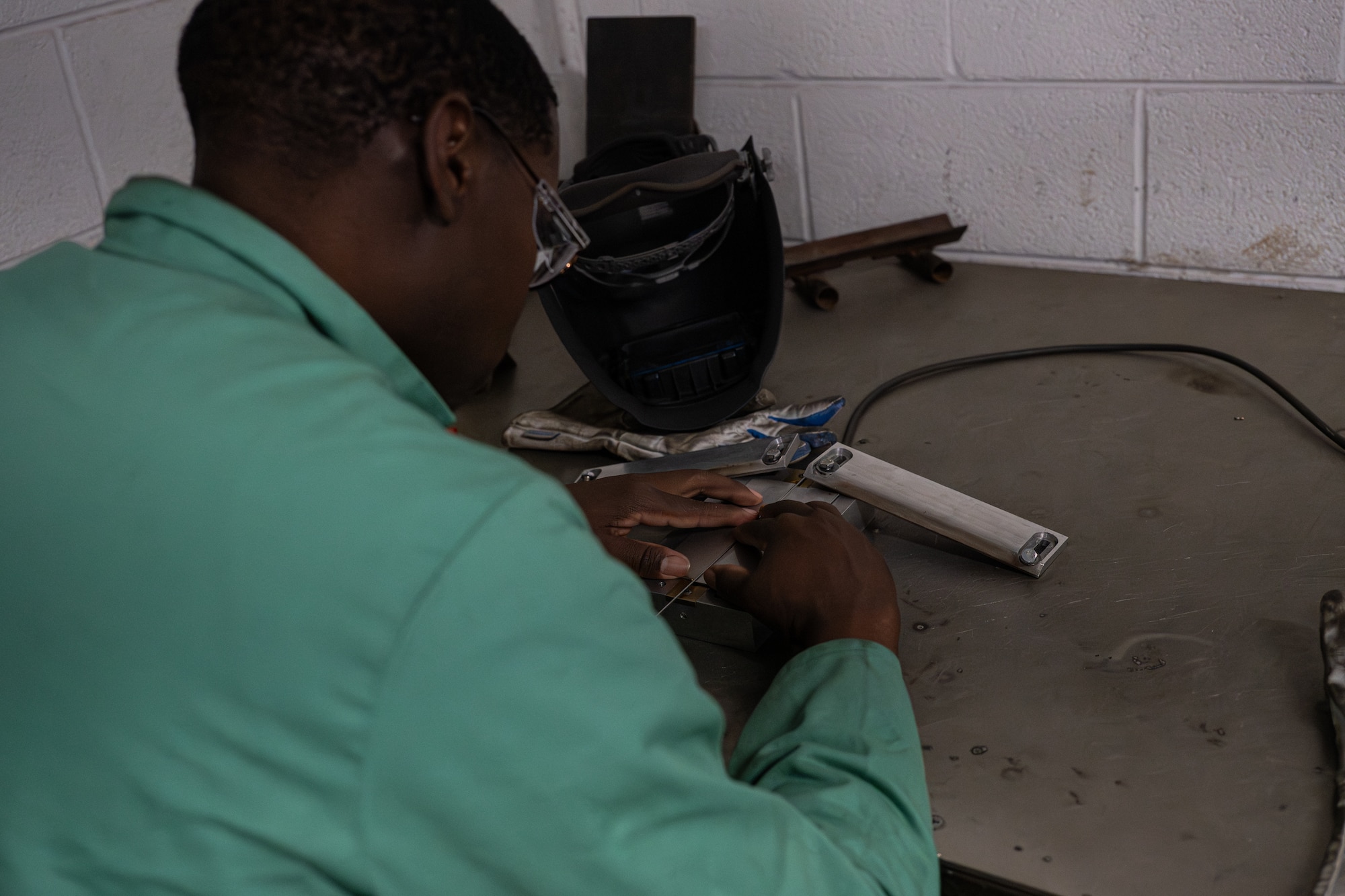 U.S. Air Force Airman 1st Class Joseph Williams, 436th Maintenance Squadron metals technology apprentice, carefully aligns pieces of metal together before welding them into one on Dover Air Force Base, Delaware, June 4, 2026.