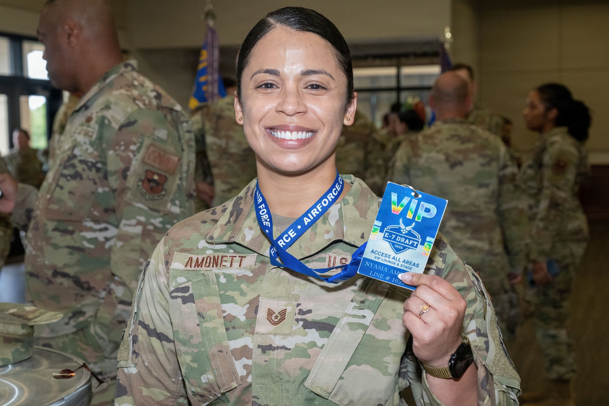 A woman in a military uniform holds up a VIP pass.