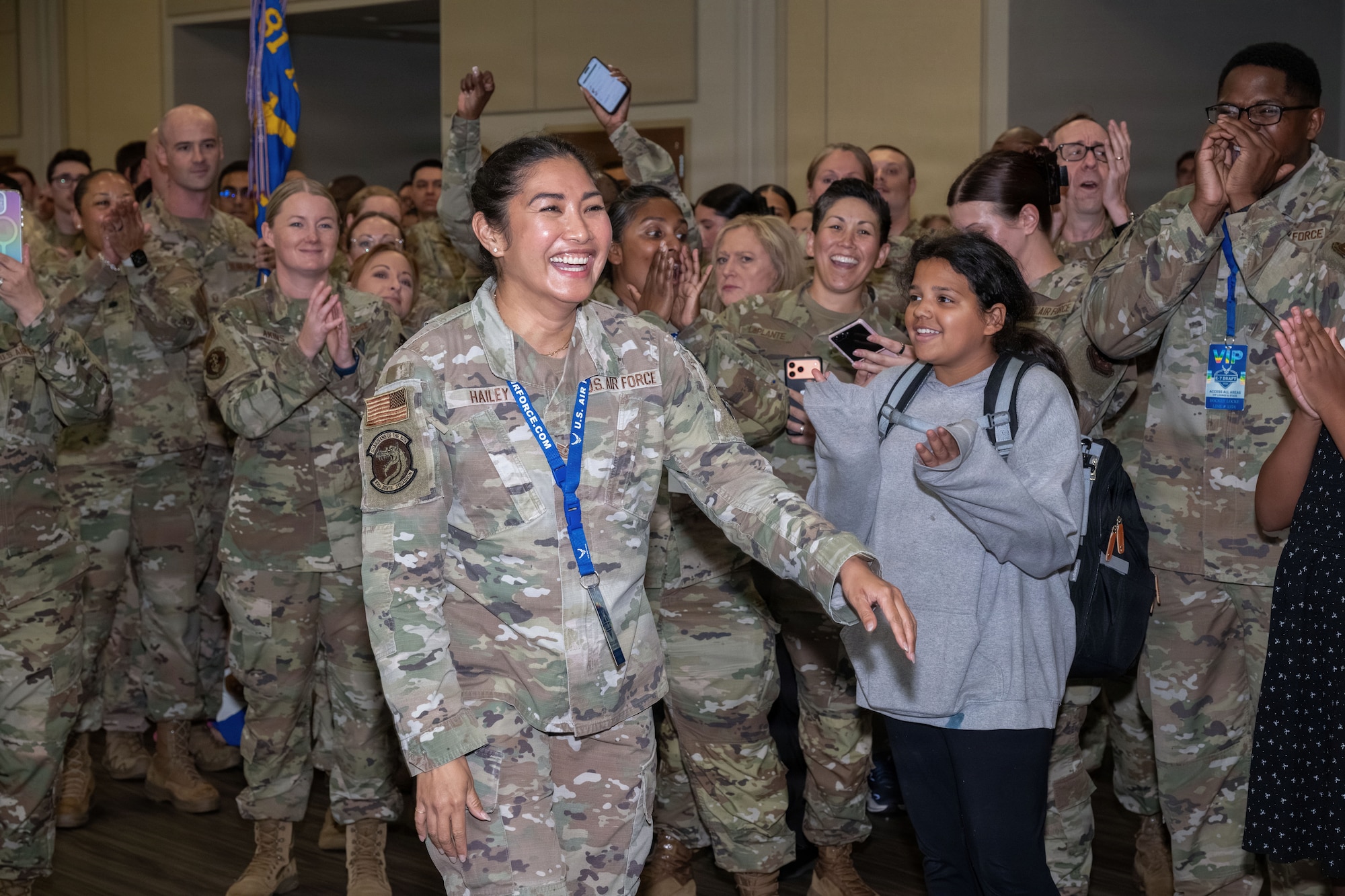 A woman makes her way through a crowd of people while smiling.