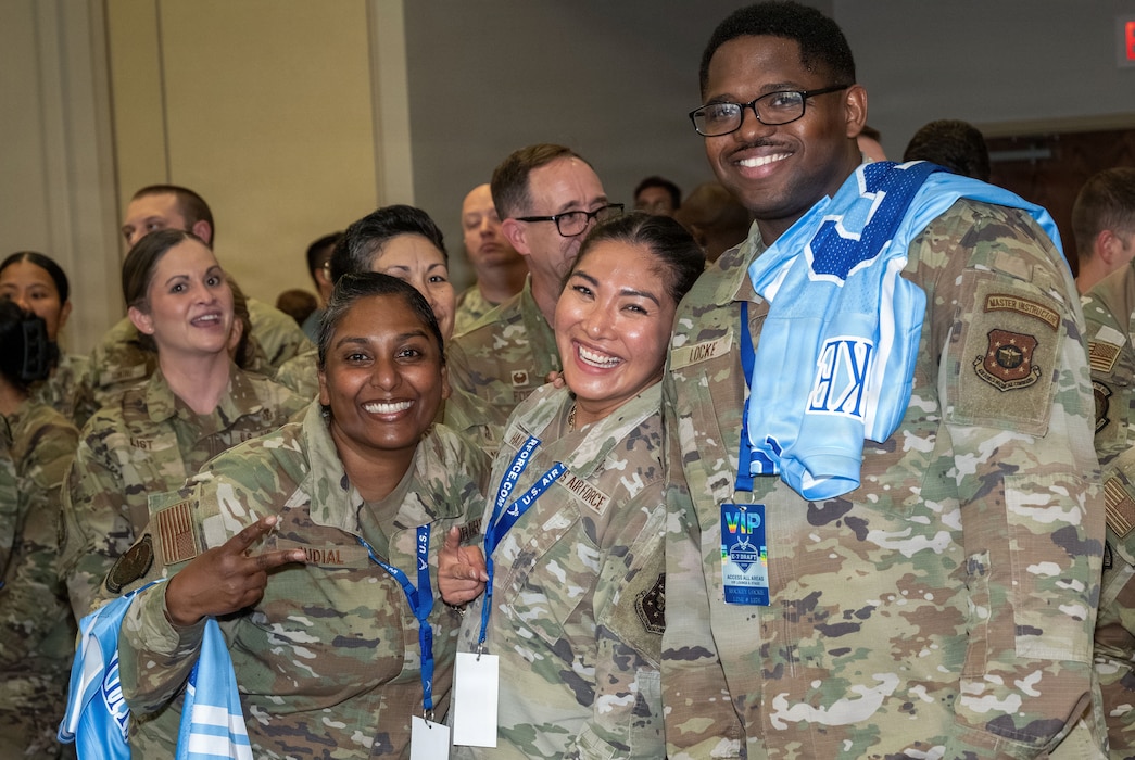 A group of people in military uniforms pose for a group photo.