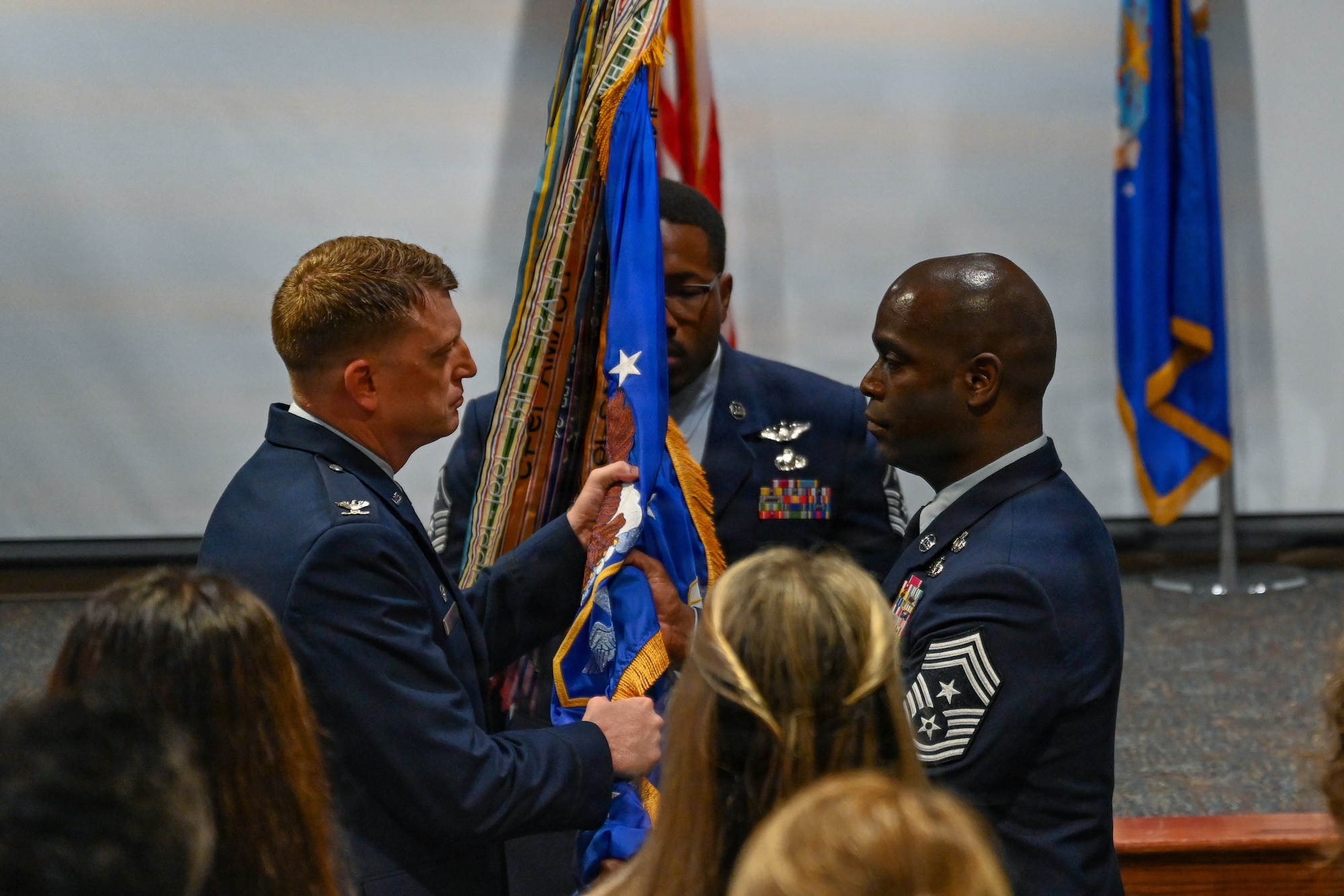 Chief Master Sgt. Ralph Oliver, 1st Special Operations Wing outgoing command chief, right, passes the 1st SOW guidon to Col. Mark Hamilton, 1st SOW commander, left, during a change of responsibility ceremony at Hurlburt Field, Florida, June 5, 2026.