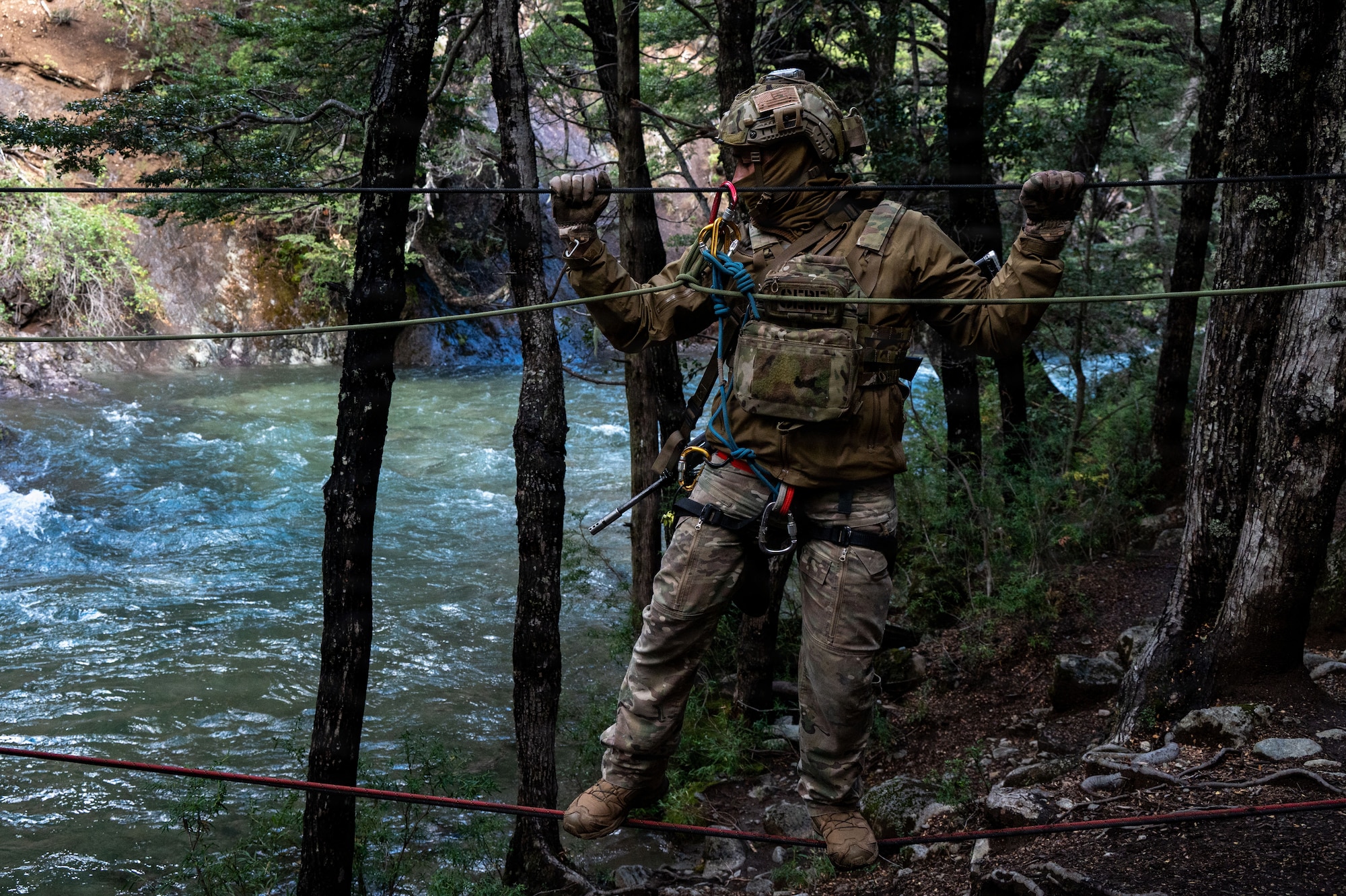 A U.S. Airman assigned to the 492nd SOW crosses a rope bridge over a river at the Escuela Militar de Montaña in Bariloche, Argentina.