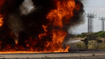 U.S. Marine Corps Pfc. Santino Deavila, an aircraft rescue firefighter with Headquarters and Headquarters Squadron, Marine Corps Air Station Miramar, suppresses a burn pit during a simulated aircraft burn training exercise at MCAS Miramar, San Diego, California, May 30, 2026. The mock aircraft burn pit provides realistic training for firefighters to reinforce emergency response procedures for potential aircraft incidents. (U.S. Marine Corps photo by Lance Cpl. Zoey Williams)