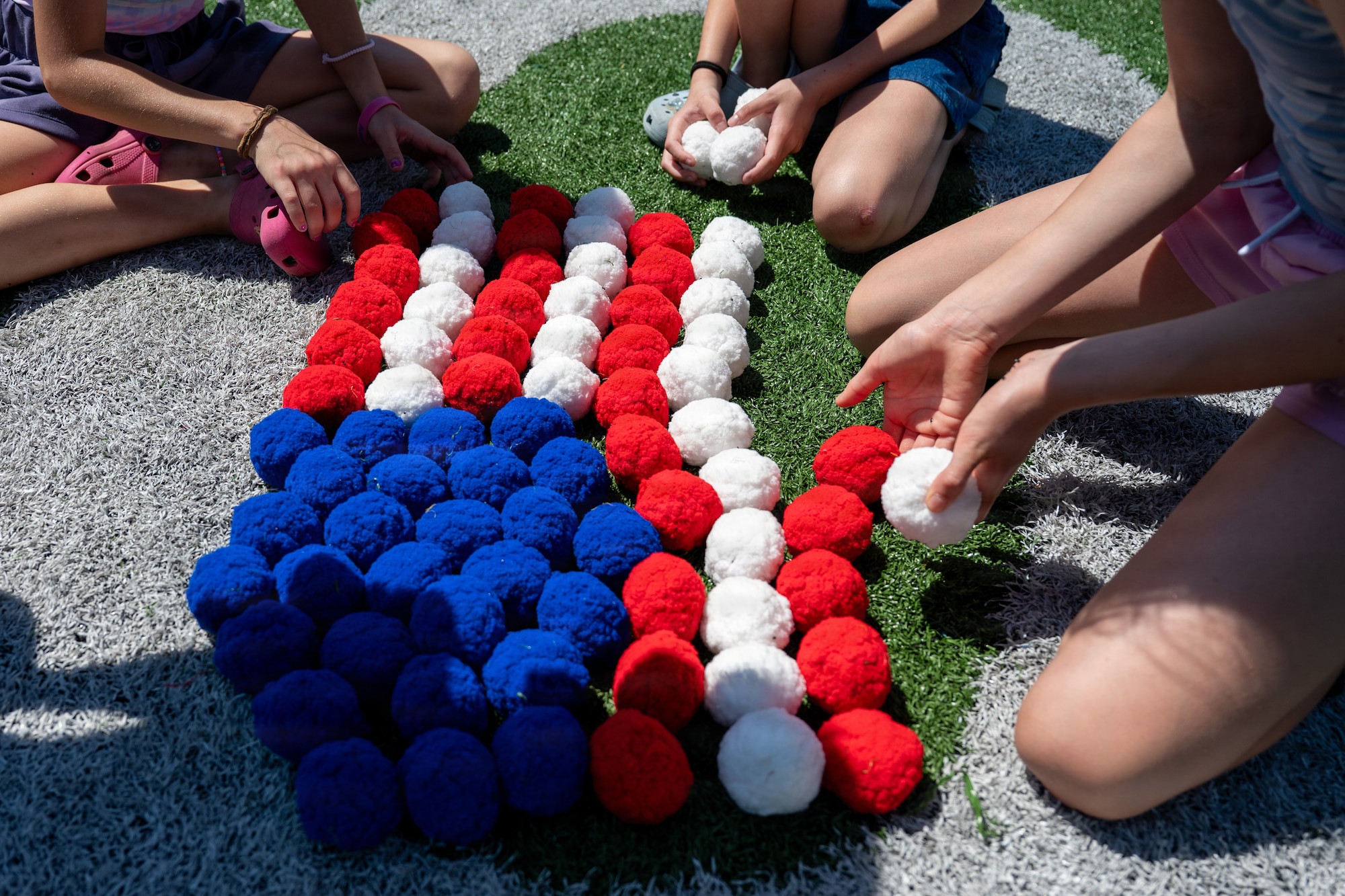 Military children build the American flag with reusable water toys during Operation Discovering and Exploring Military Operations at Hurlburt Field, Florida, April 11, 2026.