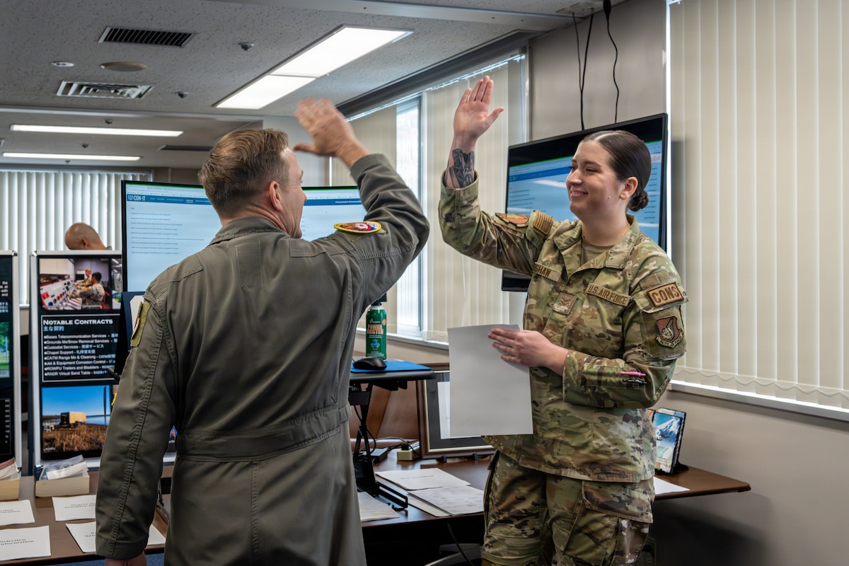 U.S. Air Force Col. Paul Davidson, left, 35th Fighter Wing commander, celebrates the awarding of a contract with Airman 1st Class Katie Kershaw, 35th Contracting Squadron (CONS) contract specialist, during a Wild Weasel Walk-Through.