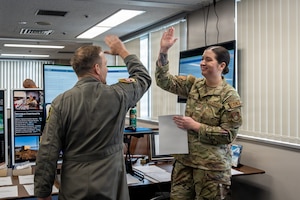 U.S. Air Force Col. Paul Davidson, left, 35th Fighter Wing commander, celebrates the awarding of a contract with Airman 1st Class Katie Kershaw, 35th Contracting Squadron (CONS) contract specialist, during a Wild Weasel Walk-Through.