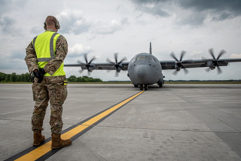 A crew chief assigned to the 123rd Airlift Wing, Kentucky Air National Guard, marshals a U.S. Air Force C-130J Super Hercules aircraft on the flight line at Karup Air Base, Denmark, June 2, 2026. The 123rd AW is providing tactical airlift support to NATO Allies throughout the month of June in support of Ramstein Flag 2026, an Allied Air Command large-scale, air-focused, multi-location and joint operating area exercise with 18 participating nations and more than 200 aircraft. (U.S. Air National Guard photo by Master Sgt. Joshua Horton)