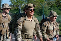 Three service members smile while walking together