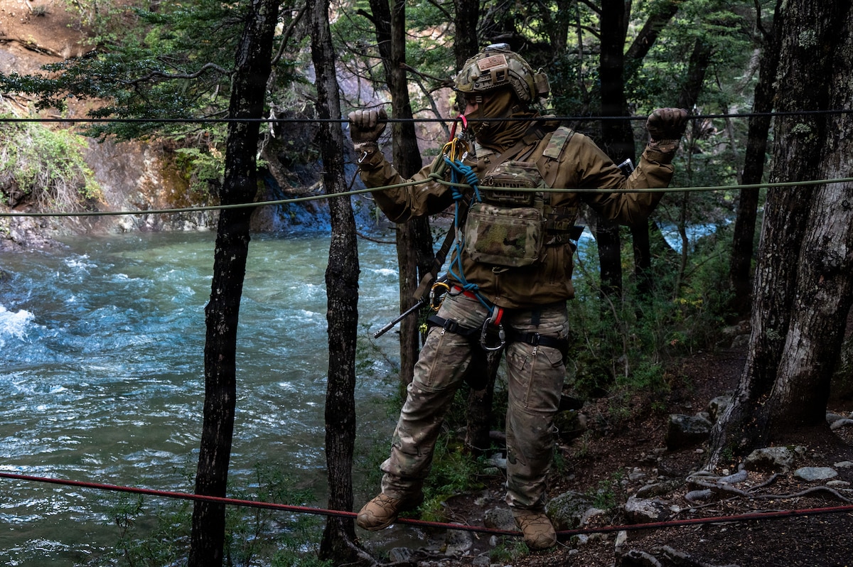 A U.S. Airman assigned to the 492nd SOW crosses a rope bridge over a river at the Escuela Militar de Montaña in Bariloche, Argentina.