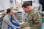 Ensign Megan McLaughlin, a fourth-year medical student at the Uniformed Services University of the Health Sciences, performs a musculoskeletal examination during her Advanced Clerkship Rotation with the Orthopedics Department at U.S. Naval Hospital Rota, Spain. The rotation provides future Navy physicians opportunities to enhance clinical skills, work alongside experienced Navy Medicine providers, and gain firsthand insight into the role military medicine plays in supporting operational readiness and warfighter health. (U.S. Navy photo by Lt. Cmdr. Alicia Sacks)