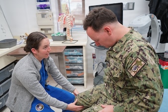 Ensign Megan McLaughlin, a fourth-year medical student at the Uniformed Services University of the Health Sciences, performs a musculoskeletal examination during her Advanced Clerkship Rotation with the Orthopedics Department at U.S. Naval Hospital Rota, Spain. The rotation provides future Navy physicians opportunities to enhance clinical skills, work alongside experienced Navy Medicine providers, and gain firsthand insight into the role military medicine plays in supporting operational readiness and warfighter health. (U.S. Navy photo by Lt. Cmdr. Alicia Sacks)