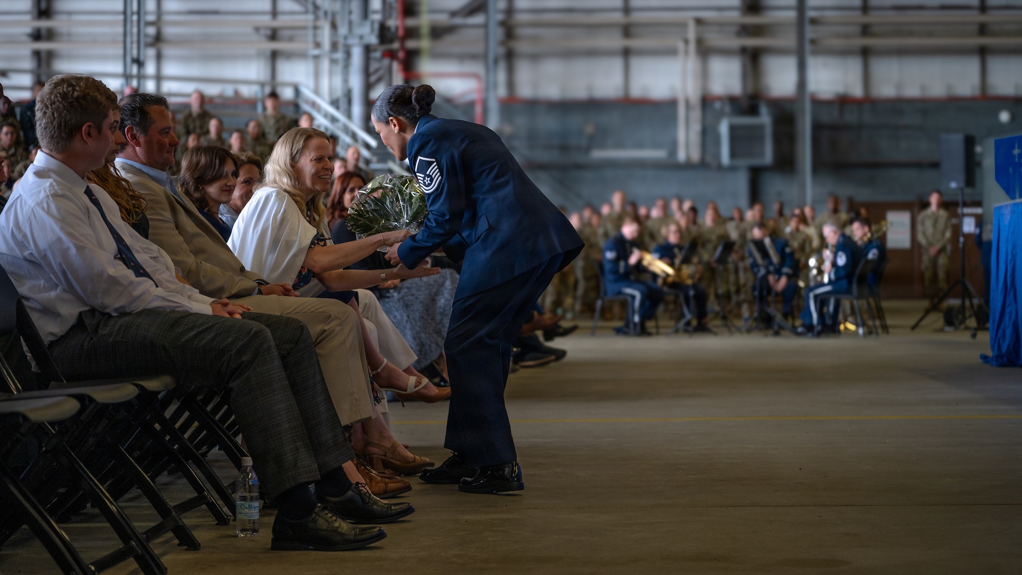A photo of an Airman giving a family flowers