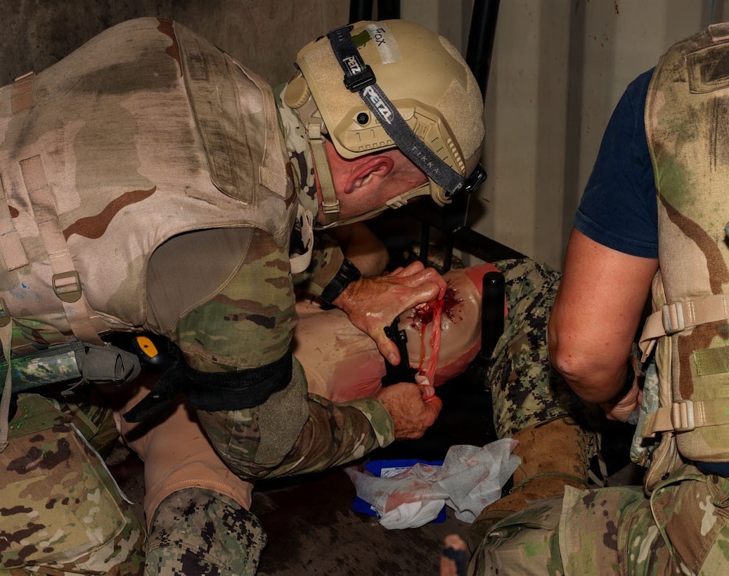 An Airman puts gauze over a simulated wound.