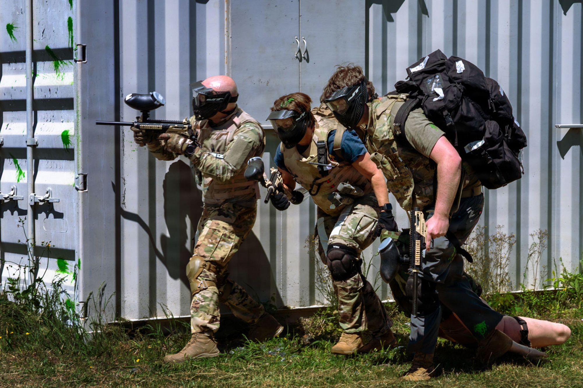 Three U.S. Air Force Airmen carry a manikin.