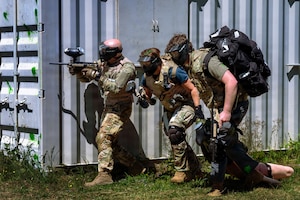 Three U.S. Air Force Airmen carry a manikin.