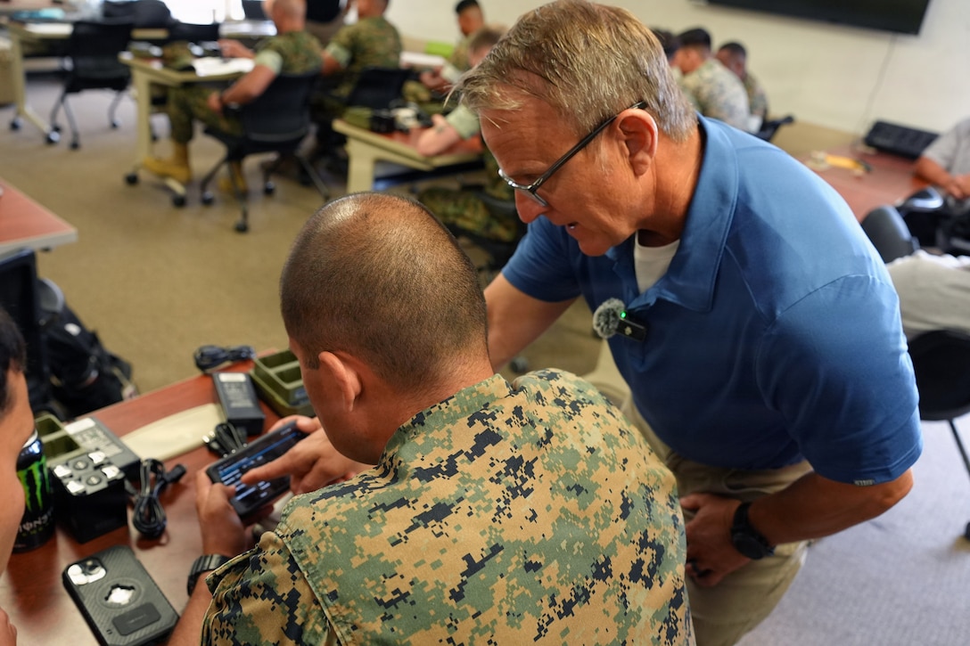 A civilian instructor trains a U.S. Marine on the use of an Sensitive but Unclassified - Encrypted (SBU-E) network node as part of Marine Corps Tactical Systems Support Activity's (MCTSSA) Expeditionary Warfare Operations Kit (EWOK). EWOK is self contained, secure, commercial-grade tactical network designed to turn frontline Marines into sensors. (U.S. Marine Corps Photo by Joseph R. Vincent, CTR)