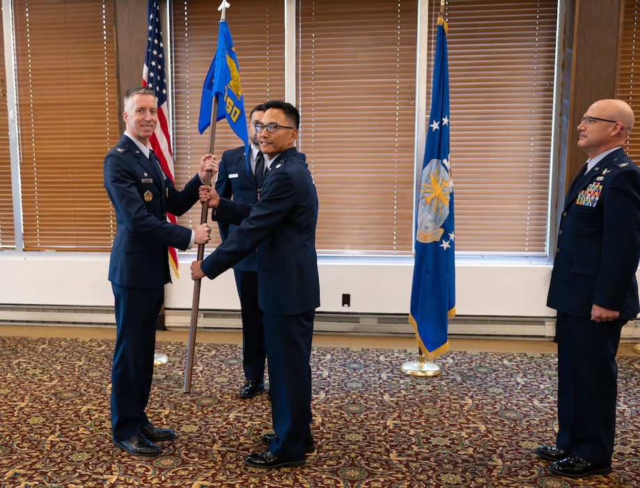 Lt. Col. Evan Valdez, center, takes the guidon from Arnold Engineering Development Complex Commander Col. Grant Mizell, left, to assume the role of AEDC Test Support Division chief during a June 5, 2026, Change of Leadership ceremony at Arnold Air Force Base, Tenn., headquarters of AEDC. Also pictured is outgoing TSD chief Col. Eric Withrow. (U.S. Air Force photo by Diamond Brown)