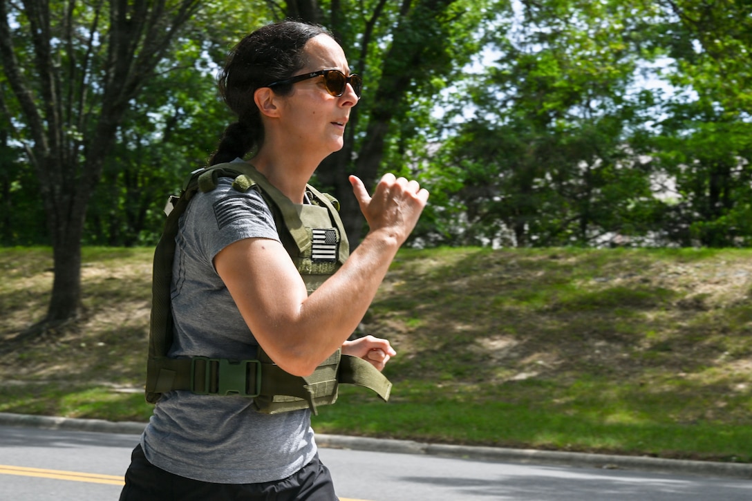 A woman runs next to a road.