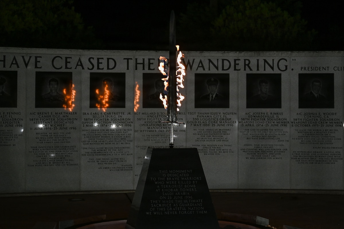 A flaming sword wedged into a stone block sits in the middle of a memorial that explains its purpose.