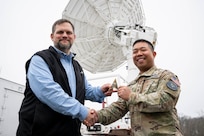 Keith Akins (left), U.S. Naval Research Laboratory (NRL) aerospace engineer, and Maj. Joel Atienza, U.S. Space Force (USSF) range integration capability lead, pose for a photo with a satellite tracking antenna system at the Blossom Point Tracking Facility in Welcome, Md. March 5, 2026. NRL and USSF partnered to support expanded joint testing and operational readiness for space systems, reinforcing collaboration between the naval and space communities. (U.S. Navy photo by Sarah Peterson)