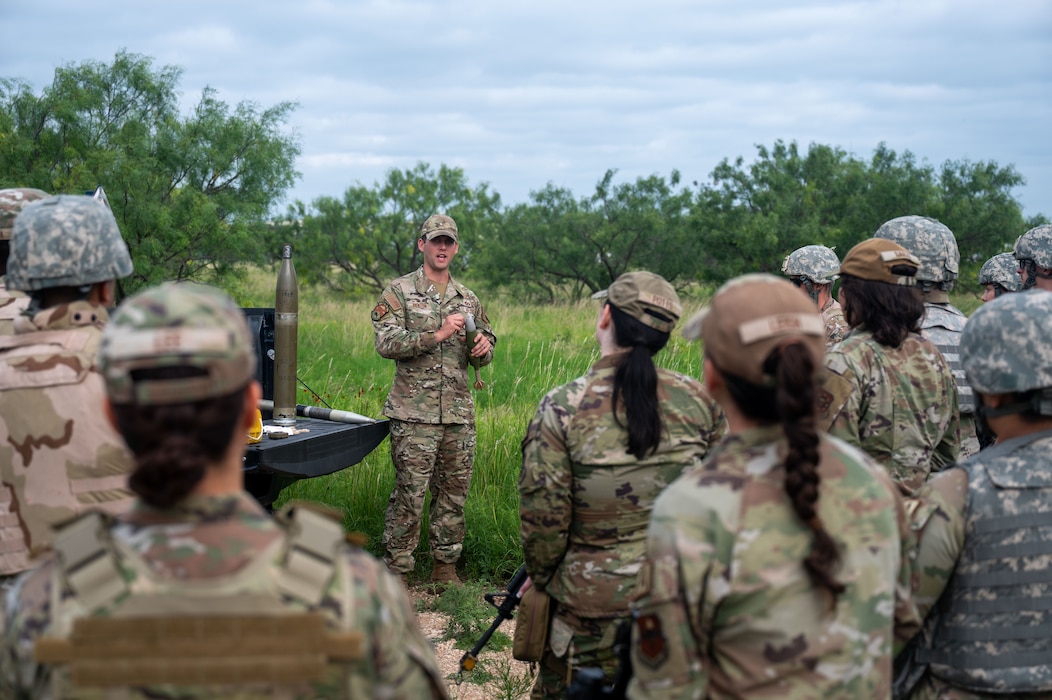 U.S. Air Force Staff Sgt. Austin Denton, 7th Civil Engineer Squadron explosive ordnance disposal flight team lead, briefs Airmen assigned to the 17th Training wing on unexploded ordnance identification procedures during the inaugural Ready Airman Training Day at Goodfellow Air Force Base, Texas, Aug. 8, 2026. The scenario required Airmen to follow proper reporting procedures while simultaneously countering the spread of misinformation among a simulated local population. (U.S. Air Force photo by Senior Airman James Salellas)