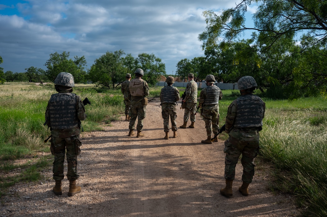 Airmen assigned to the 17th Training Wing scan a route for unexploded ordnance during the inaugural Ready Airman Training Day at Goodfellow Air Force Base, Texas, Aug. 8, 2026. The scenario required participants to identify and report simulated UXO while moving through a designated area, replicating the split-second recognition and reporting demands Airmen face in deployed environments. (U.S. Air Force photo by Senior Airman James Salellas)