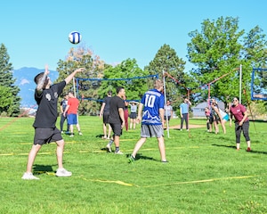 A player winds up to serve a volleyball, while he's team is waiting for the match to start.